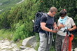 Young couple of hikers with compass and map in the mountains