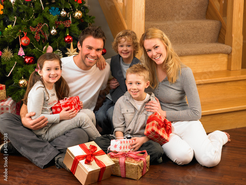 Photo: Family with gifts in front of Christmas tree Family with gifts in front of Christmas tree