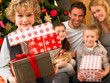Family with gifts in front of Christmas tree