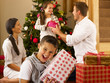 Hispanic family exchanging gifts at Christmas
