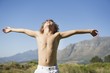 Photo: Shirtless little boy standing with his eyes closed and arms outstretched against mountain Shirtless little boy standing with his eyes closed and arms outstretched against mountain