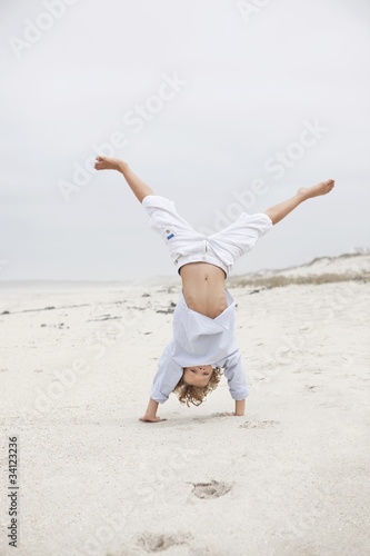 Photo: Boy doing handstand on beach Boy doing handstand on beach