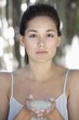 Portrait of a beautiful young woman holding bath salt in hand