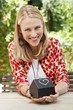 Foto: Woman holding a model home and smiling Woman holding a model home and smiling