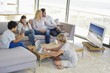 Couple watching television set while their children busy in different activities