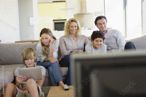 Photo: Family watching TV together at home Family watching TV together at home