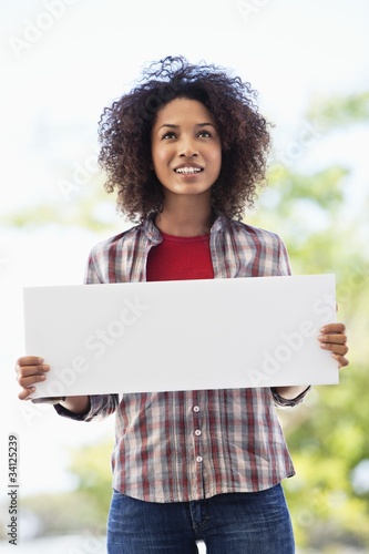 Photo: Woman holding a blank placard Woman holding a blank placard