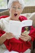 Senior woman reading a magazine and looking surprised