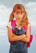 angry schoolgirl against cloudy sky