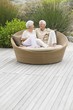 Senior couple sitting in a wicker couch