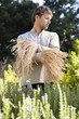 Young man standing in a field as scarecrow