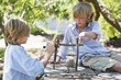 Children making frame of driftwood outdoors