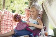 Smiling little girl holding toys in tree house