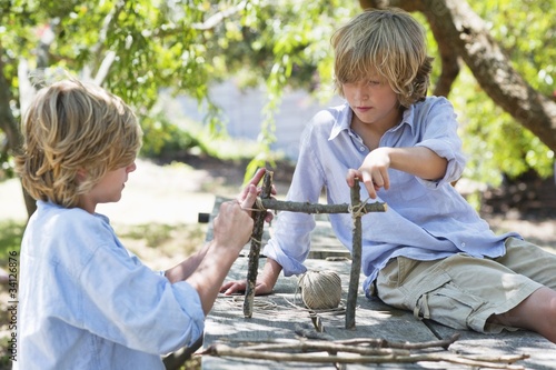 Photo: Children making frame of driftwood outdoors Children making frame of driftwood outdoors