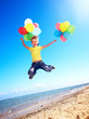Child playing with balloons at the beach