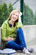 Teenage girl sitting outdoors