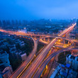 Freeway in night with cars light in modern city.