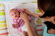 Photo: young mother dressing her baby young mother dressing her baby