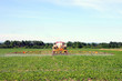 Foto: Full rear view of tractor spraying pesticides on crop Full rear view of tractor spraying pesticides on crop