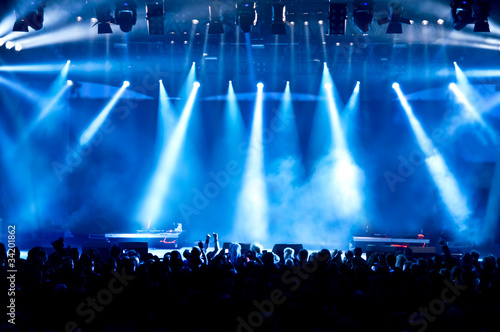 Photo: concert crowd in front of bright blue stage lights concert crowd in front of bright blue stage lights