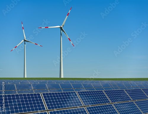 Foto: Windkrafträder und Solarmodule in einem Feld Windkrafträder und Solarmodule in einem Feld