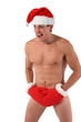 Sexy muscular man screams wearing a Santa Claus hat