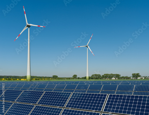 Foto: Solarmodule und Windkrafträder vor einem Rapsfeld Solarmodule und Windkrafträder vor einem Rapsfeld