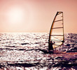 Windsurfer silhouette over sea sunset