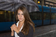 Young woman in the street during rainy evening