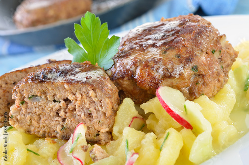 Foto: Knusprig gebratene Frikadellen auf Kartoffelsalat Knusprig gebratene Frikadellen auf Kartoffelsalat
