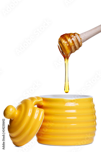 Photo: Honey pot and dipper isolated on white Honey pot and dipper isolated on white
