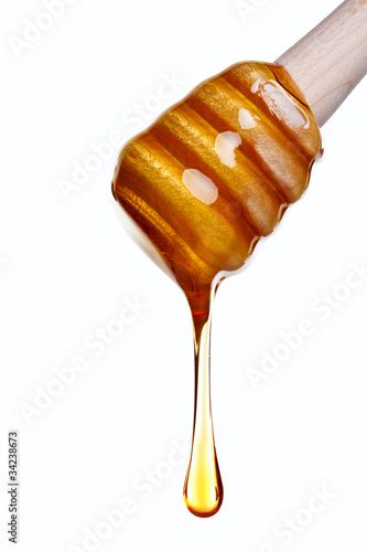Photo: Honey dripping from a wooden dipper Honey dripping from a wooden dipper