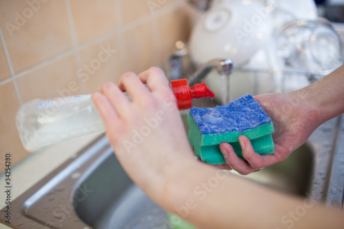Photo: Washing of the dishes - woman hands rinsing dishes Washing of the dishes - woman hands rinsing dishes