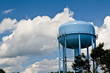 blue water tower under cloudy skies