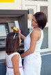 Happy family withdrawing money from credit card at ATM