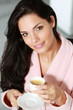 Jeune femme buvant un café au petit déjeuner
