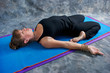 Photo: woman on mat in studio doing yoga posture reclined hero pose woman on mat in studio doing yoga posture reclined hero pose