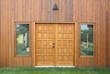 wooden door on a stone wall with green grass in front