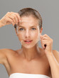 Photo: young woman taking off peeling mask young woman taking off peeling mask