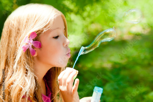 Photo: Children blowing soap bubbles in outdoor forest Children blowing soap bubbles in outdoor forest