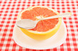 Halved red grapefruit on tablecloth