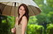 Beautiful woman holding umbrella out in the rain