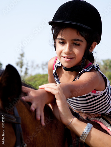 Photo: bambina accarezza dorso del cavallo bambina accarezza dorso del cavallo