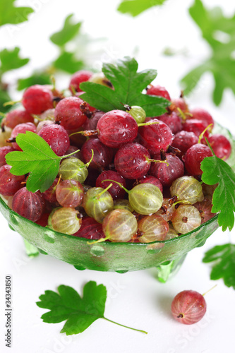 Photo: Fresh gooseberry and green leaves on white background isolated Fresh gooseberry and green leaves on white background isolated