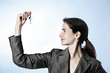 Profile of woman holding key between fingers