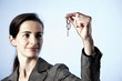 Business woman holding key between fingers