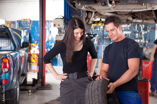 Photo: Mechanic Showing Tire to Woman Customer Mechanic Showing Tire to Woman Customer