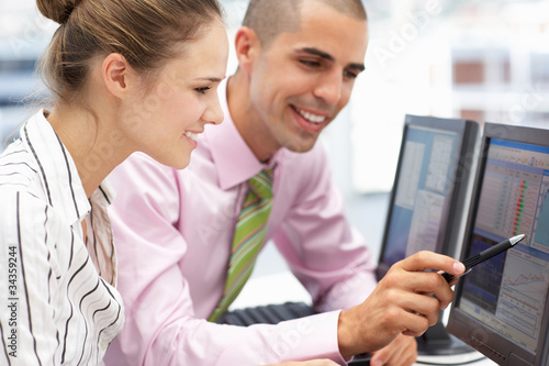 Photo: Businessman and woman working on computers Businessman and woman working on computers