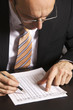 Foto: Businessman studying a table Businessman studying a table