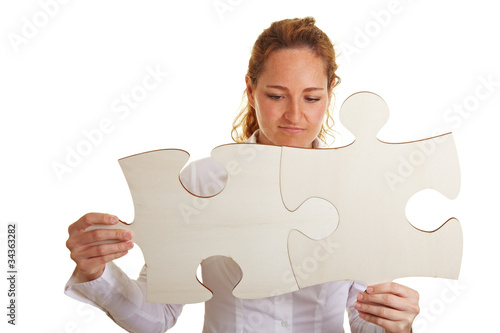 Foto: Frau setzt zwei Puzzleteile zusammen Frau setzt zwei Puzzleteile zusammen